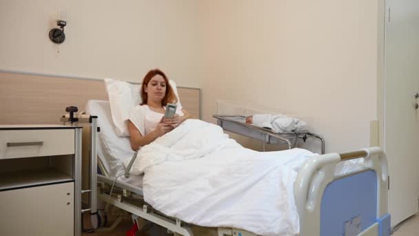 Una Mujer Baja Sofá Del Hospital Usando Control Remoto Madre — Vídeo de stock