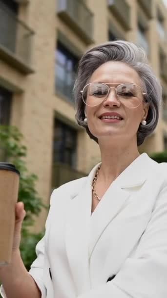 Όμορφη Καυκάσια Ηλικιωμένη Γκριζομάλλα Επιχειρηματίας Που Πίνει Καφέ Έξω Κάθετη — Αρχείο Βίντεο