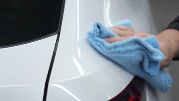 Ένας Μηχανικός Σκουπίζει Σώμα Ενός Λευκού Αυτοκινήτου Ένα Πανί Μικροϊνών — Αρχείο Βίντεο