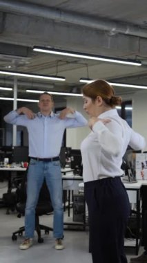 Ofis çalışanları molada ısınırlar. Çalışanlar iş yerinde fitness egzersizleri yaparlar. Ağır çekim. Dikey video