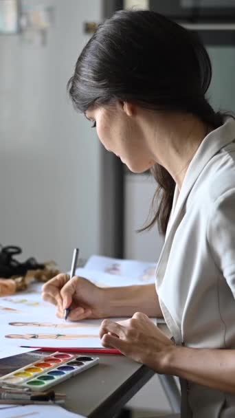 白人女性が机にスケッチを描いている バーティカルビデオ — ストック動画