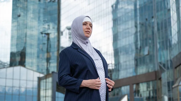 Portrait of a pregnant business woman in hijab and suit outdoors