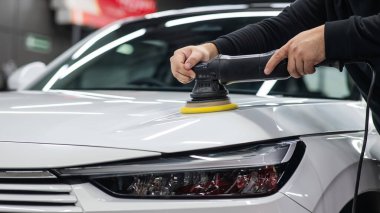 Yörüngesel cilalama makinesi kullanılarak beyaz arabanın kaput yüzeyinin parlatılması işlemi