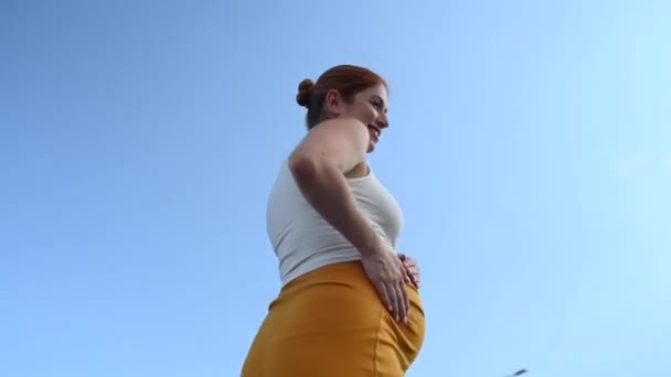 ビデオ 360度 カメラを見ている幸せな白人妊婦と優しく屋外で彼女の腹に触れる — ストック動画