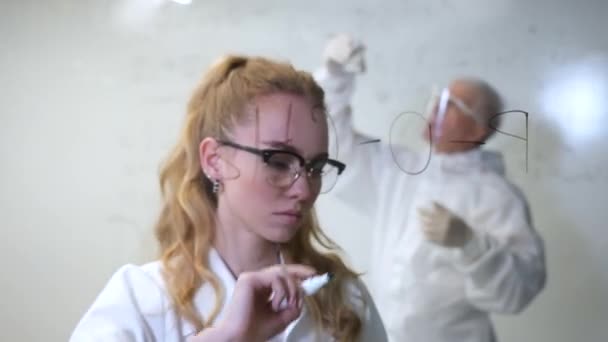 Una Mujer Química Escribe Una Fórmula Vidrio Hombre Caucásico Edad — Vídeos de Stock