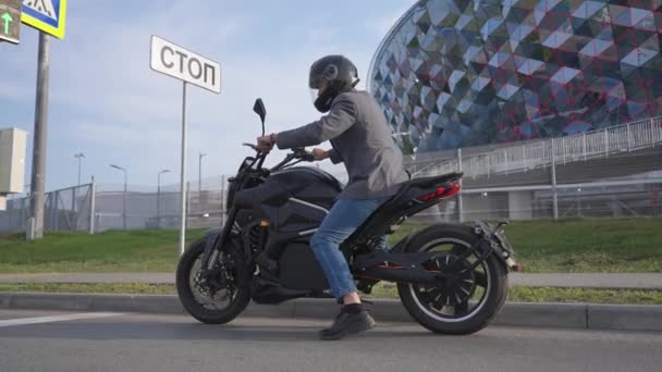 Kafkasyalı Bir Adam Modern Bir Binanın Önünden Elektrikli Motosikletle Geçiyor — Stok video