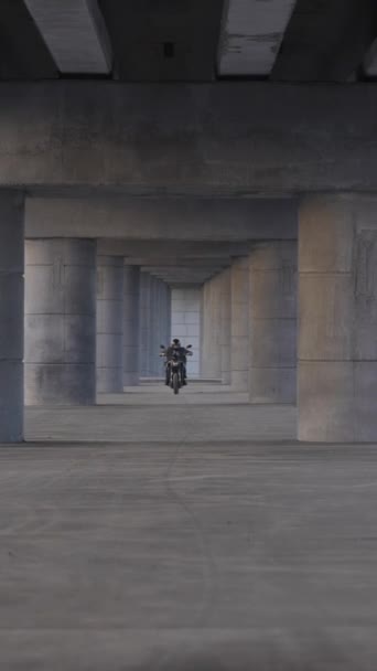 Ceketli Kasklı Bir Adam Köprünün Altında Elektrikli Motosiklet Sürüyor Dikey — Stok video