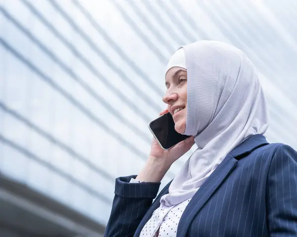 Business woman in hijab and suit talking on smartphone