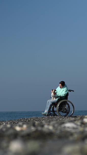 Mulher Caucasiana Uma Cadeira Rodas Abraçando Com Cão Perto Mar — Vídeo de Stock