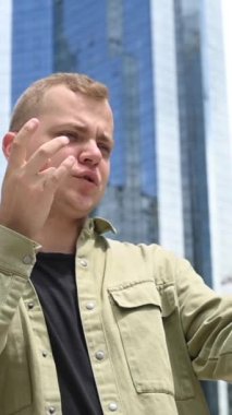 Beyaz adam açık havada akıllı telefondan işaret dili konuşuyordu. Dikey video