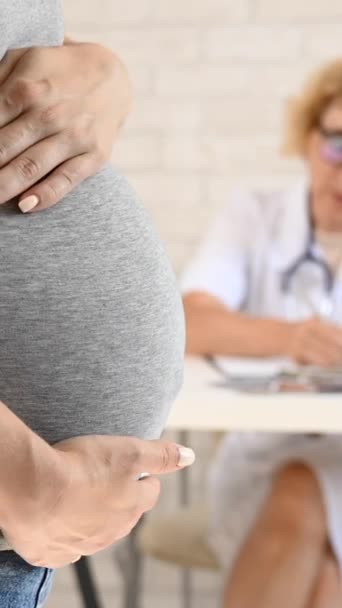 Arzt Gynäkologe Geburtshilfe Seinem Schreibtisch Hintergrund Nahaufnahme Einer Schwangeren Frau — Stockvideo