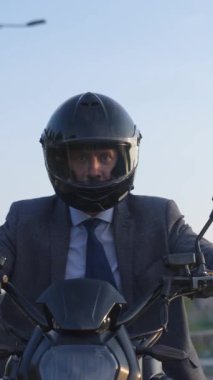 Beyaz bir adam elektrikli motosiklet kullanıyor. Dikey video