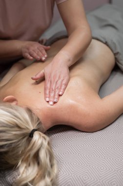 Rahim boynu bölgesinde masaj yaptıran bir kadın. Dikey fotoğraf