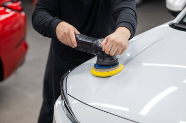 Yörüngesel cilalama makinesi kullanılarak beyaz arabanın kaput yüzeyinin parlatılması işlemi