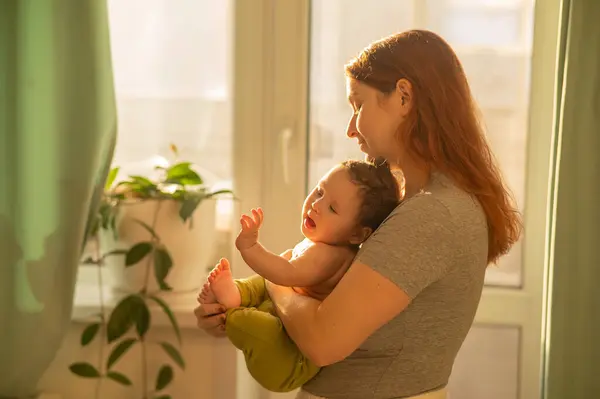 Kafkasyalı Kadın Yeni Doğmuş Oğlunu Nazikçe Kucağına Alıp Pencerenin Yanında — Stok fotoğraf