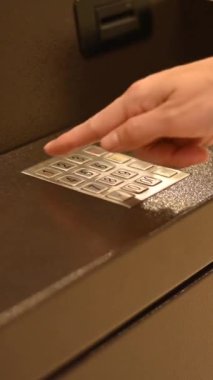 Yüzsüz kadın ATM 'de banka kartı şifresini çeviriyor. Dikey video