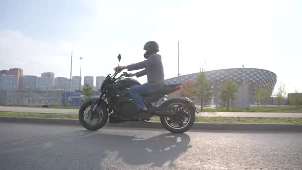 Biały Mężczyzna Jedzie Motocyklu Elektrycznym Obok Nowoczesnego Budynku — Wideo stockowe