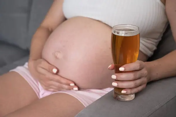 Close Barriga Uma Mulher Grávida Segurando Copo Cerveja Enquanto Senta — Fotografia de Stock