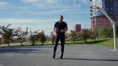 Sakallı adam spor sahasında koşmadan önce ısınıyor. Yavaş çekim