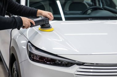 Yörüngesel cilalama makinesi kullanılarak beyaz arabanın kaput yüzeyinin parlatılması işlemi