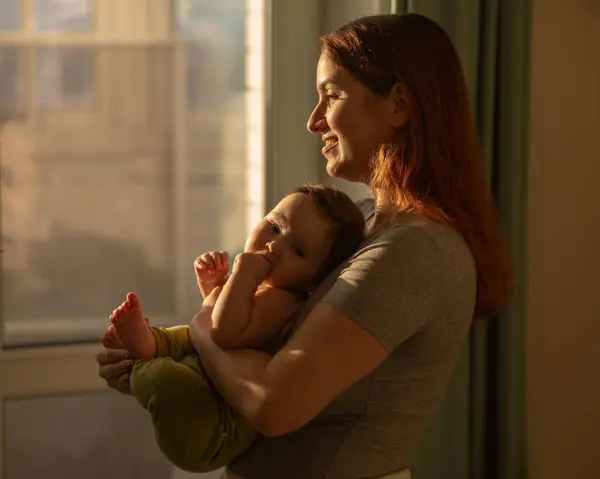 Kafkasyalı Kadın Yeni Doğmuş Oğlunu Nazikçe Kucağına Alıp Pencerenin Yanında — Stok fotoğraf