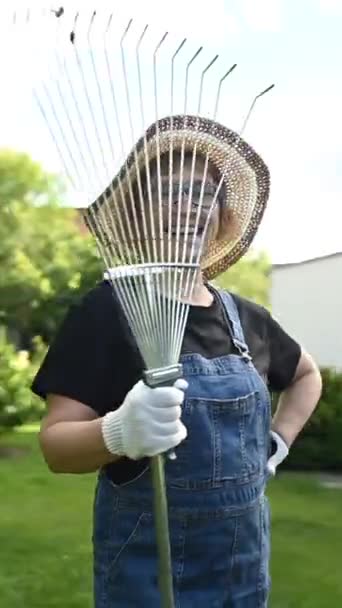 一个戴着帽子和工作服的老年妇女的画像是拿着一个园艺工具 垂直视频360度 — 图库视频影像
