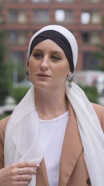 Porträtt Ung Blåögd Kvinna Som Justerar Hijab Utomhus Vertikal Video — Stockvideo
