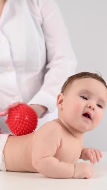 Doctor Gives Child Back Massage Using Ball Vertical Video — Stock Video