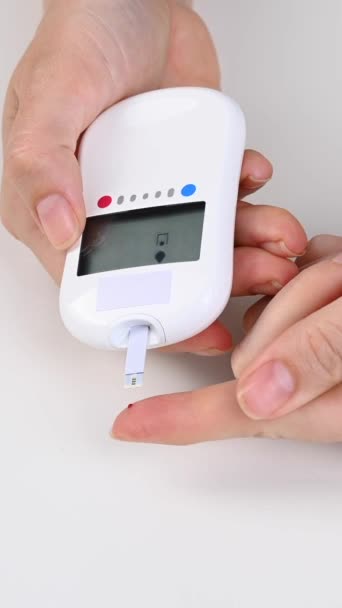 Женщина Измеряет Уровень Сахара Крови Глюкометром Вертикальное Видео — стоковое видео