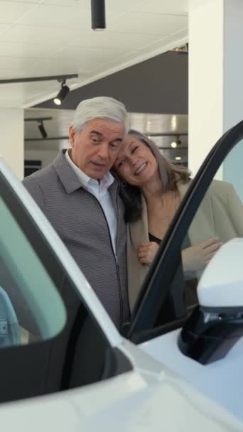 Couple Âgé Choisit Une Voiture Chez Concessionnaire Automobile Vidéo Verticale — Video