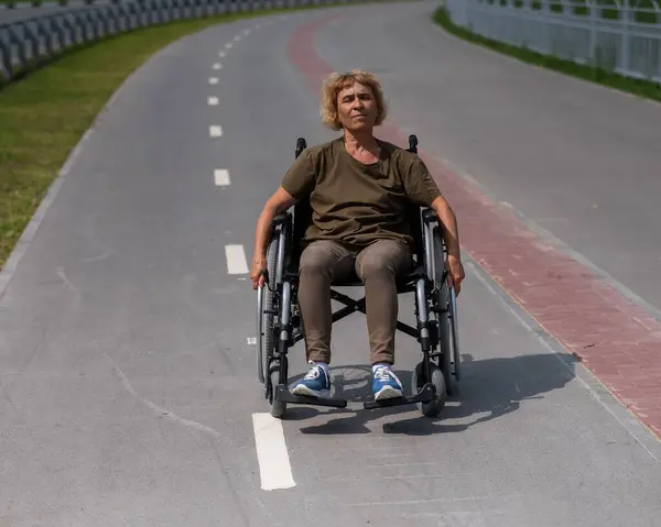 Tekerlekli Sandalyedeki Yaşlı Bir Kadın Bisiklet Yolunda Gidiyor — Stok fotoğraf