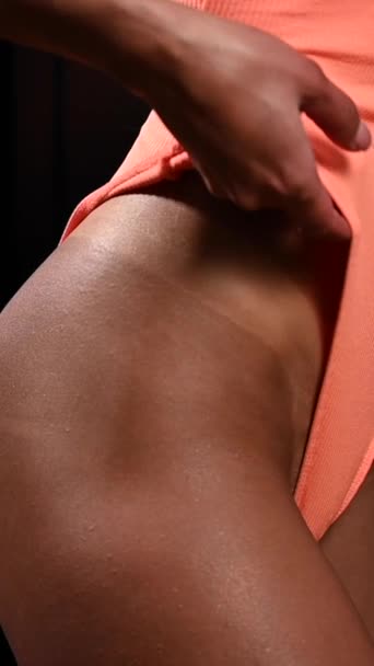 一个穿着橙色泳衣的脸色苍白的女人展示了瞬间晒黑的效果 垂直录像 — 图库视频影像