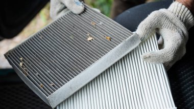 Usta arabanın kabin hava filtresini değiştiriyor.