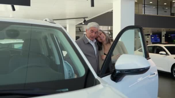 Yaşlı Beyaz Bir Çift Araba Galerisinde Yeni Bir Araba Seçiyor — Stok video