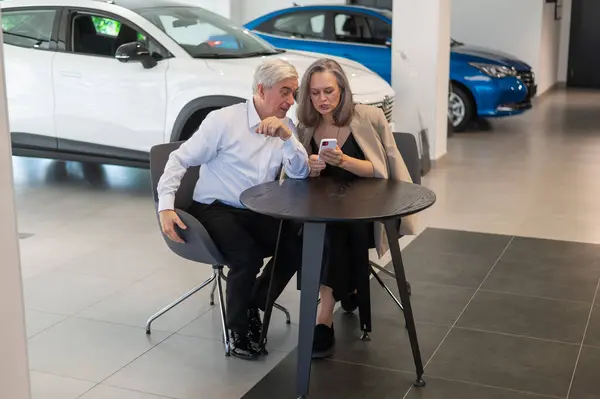 Ein Älteres Paar Sitzt Einem Autohaus Und Blickt Auf Ein — Stockfoto