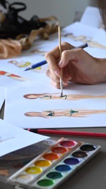 Yüzü olmayan kadın mayo çizimleri çiziyor. Moda tasarımcılarının ellerinin yakın çekimi. Dikey video