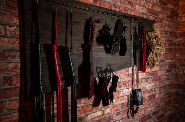 Duvarda asılı bir takım BDSM ekipmanı