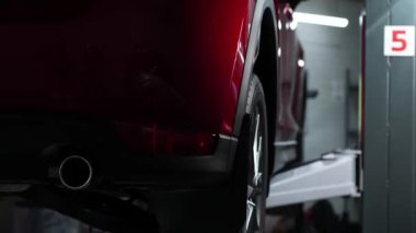 Kırmızı bir araba, bir araba hizmet merkezindeki asansörden sorunsuzca iner.