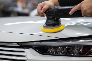 Yörüngesel cilalama makinesi kullanılarak beyaz arabanın kaput yüzeyinin parlatılması işlemi