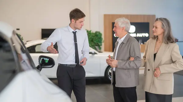 Ein Verkäufer Einem Autohaus Zeigt Einem Älteren Ehepaar Ein Auto — Stockfoto