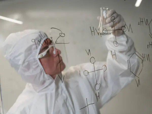 Elderly Caucasian Male Chemist Protective Suit Looks Test Tube Background — Stock Photo, Image