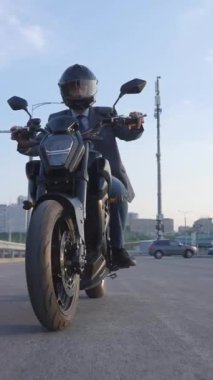 Beyaz bir adam elektrikli motosiklet kullanıyor. Dikey video