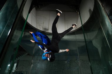 Bir erkek ve bir kadın rüzgar tünelinde birlikte uçmaktan zevk alırlar. Serbest düşüş simülatörü.