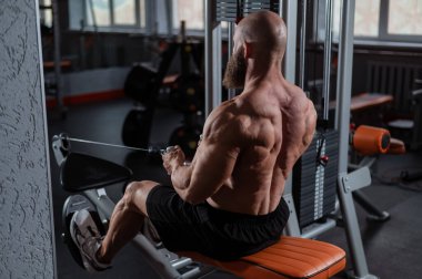 Kürek çekme makinesinde kürek çeken beyaz bir adam.