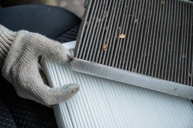 Usta arabanın kabin hava filtresini değiştiriyor.