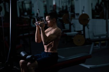 A man does a chest pulldown in the gym