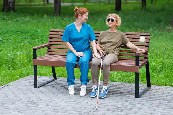 Una Enfermera Una Anciana Ciega Están Sentadas Banco Parque —  Fotos de Stock