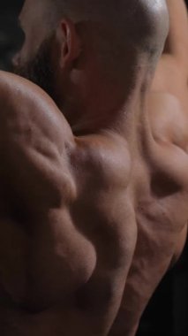 Kafkasyalı bir adam bir makinede çekiş yapıyor. Dikey video.