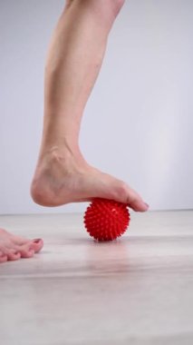 Çivili masaj topuna basan bir kadının yakın çekimi. Dikey video