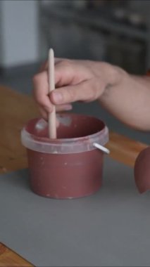 Seramik tabakları fırçayla boyayan çömlekçi elleri. Dikey video